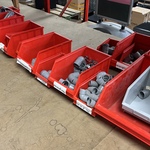 Partij magazijnbakken met buizen en hulpstukken