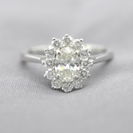 Platina entourage ring met een ovale diamant