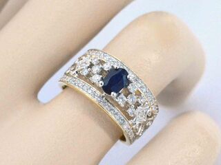 Gouden ring vol met diamanten en een saffier