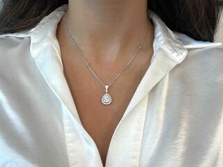Gouden druppelvormige hanger en collier vol met diamanten
