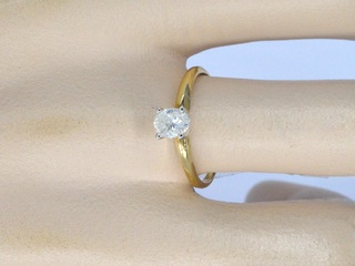 Gouden solitaire ring met een ovaal geslepen diamant in witgouden zett