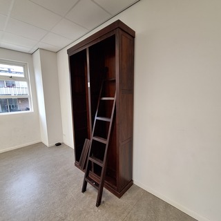 Hoge boekenkast met trap
