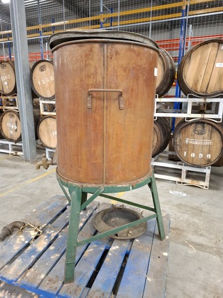 Antieke koperen drankvat op metalen onderstel