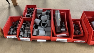 Partij magazijnbakken met buizen en hulpstukken