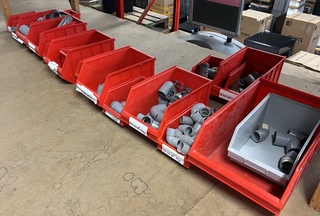 Partij magazijnbakken met buizen en hulpstukken