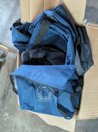 Diverse (koel)tassen en kleding in rolcontainer