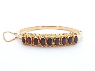 Gouden armband met rode edelstenen