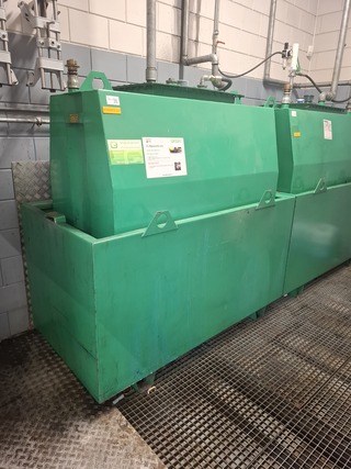 Stalen olietank in lekbak