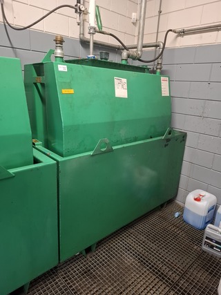 Stalen olietank in lekbak