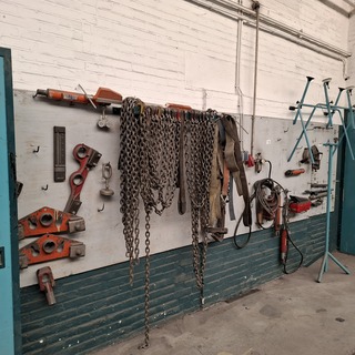 Divers richtbank en carrosserie-reparatiegereedschap op wandbord