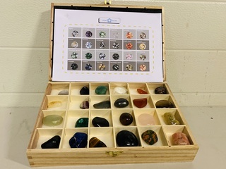 24 verschillende trommelstenen in kist