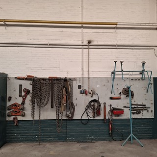 Divers richtbank en carrosserie-reparatiegereedschap op wandbord