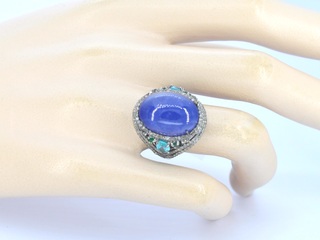 Grote ovaal gevormde ring met een tanzaniet, topazen, smaragden en nat