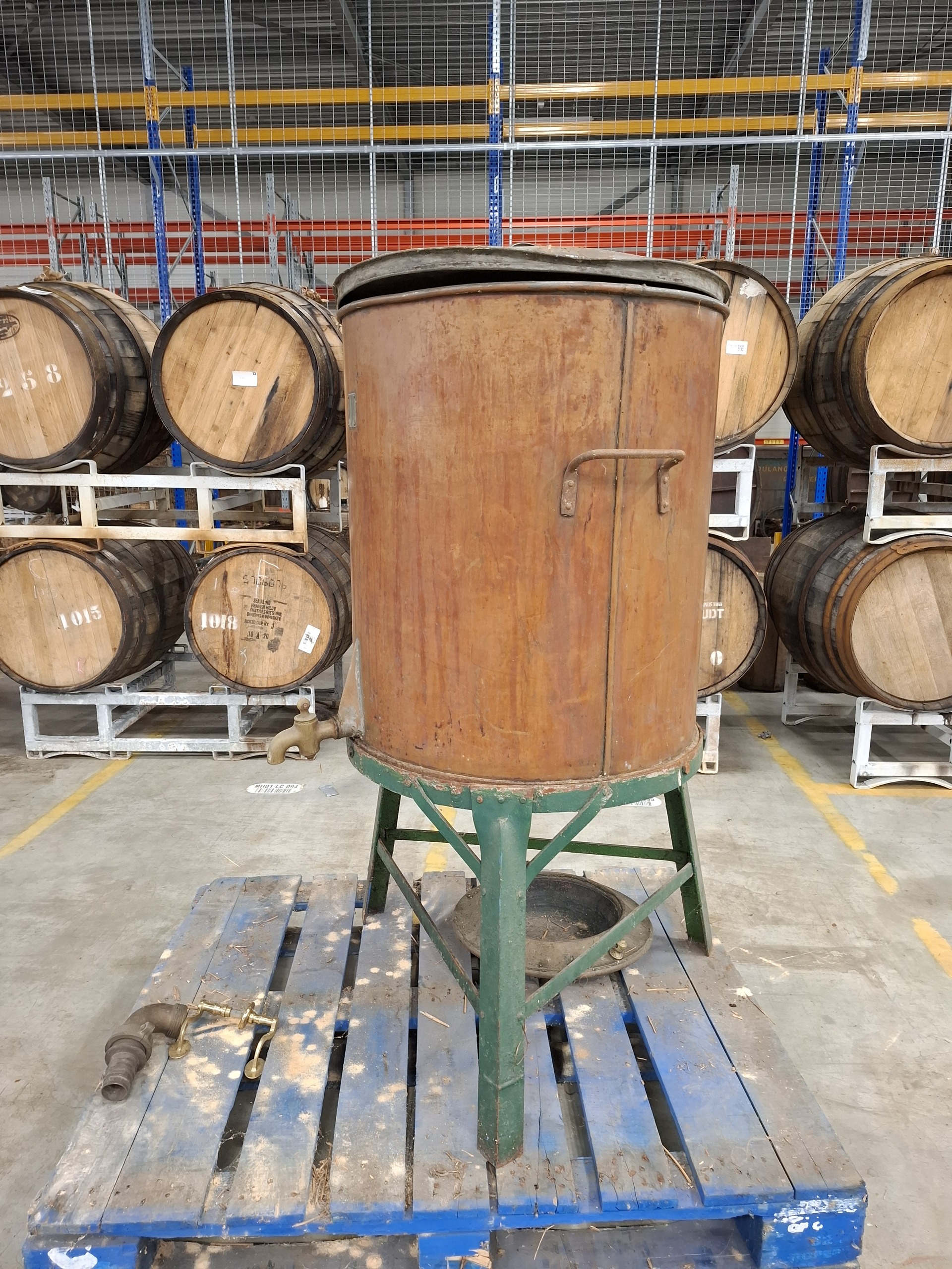 Antieke koperen drankvat op metalen onderstel